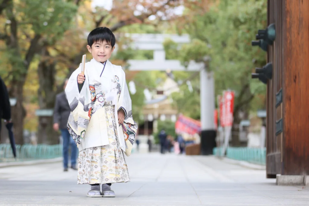 羽織袴姿の男の子が鳥居へ向かって歩く様子